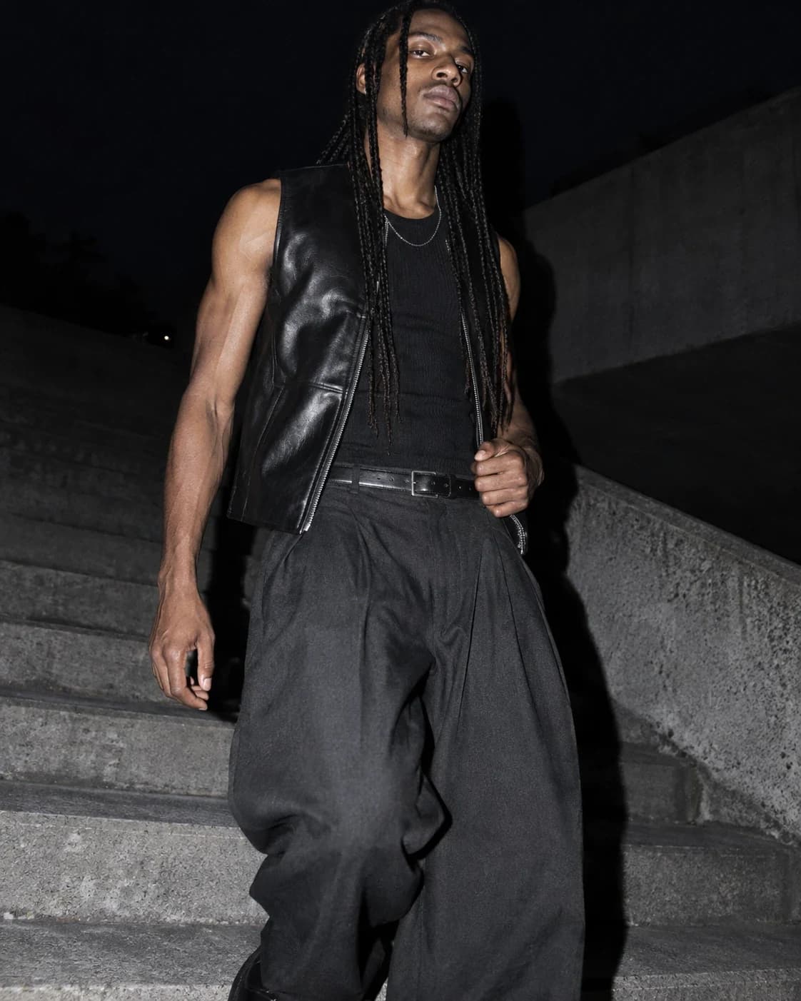 Model in leather and relaxed tailoring photographed with hard flash at night